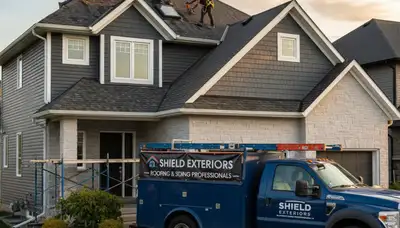 Vinyl siding contractors repairing storm-damaged roof in Knoxville, TN